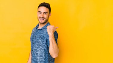 Kafkasyalı genç adam sarı fırın noktalarında izole edilmiş, başparmak uzakta, gülüyor ve kaygısız..