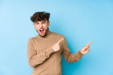 Genç Arap adam, işaret parmaklarıyla bir fotokopi alanını işaret ederek heyecan ve arzusunu ifade ediyor..