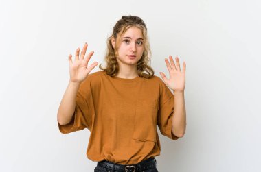 Beyaz arka plandaki genç beyaz kadın yakın bir tehlike nedeniyle şoka uğruyor.