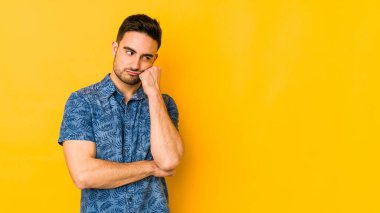 Kafkasyalı genç adam sarı fırında izole edilmiş üzgün ve dalgın hisseden, kopyalama alanına bakan.