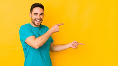 Sarı fırında izole edilmiş genç beyaz adam işaret parmağıyla işaret ederek heyecanlanıyor..