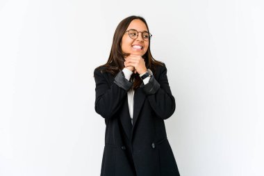 Beyaz arka planda izole edilmiş genç, melez bir iş kadını ellerini çenesinin altında tutuyor, mutlu bir şekilde yana bakıyor..