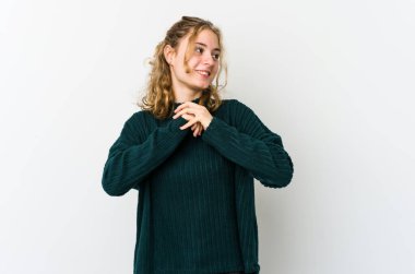 Beyaz sırtlı genç beyaz kadın ellerini çenesinin altında tutuyor, mutlu bir şekilde yan tarafa bakıyor..