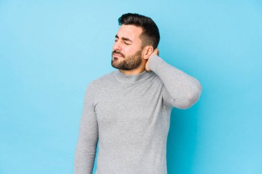 Mavi arka planda genç beyaz bir adam sabit yaşam tarzından dolayı boyun ağrısından soyutlanmış..