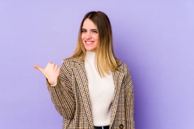 Mor arka planda izole edilmiş beyaz bir kadın işaret parmağıyla bir fotokopi alanını işaret ederek şok oldu..