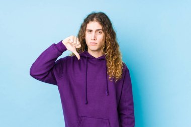 Uzun saçlı adam izole bir şekilde poz veriyor, hoşlanmadığı bir jest yapıyor, kabul etmiyor. Anlaşmazlık konsepti.