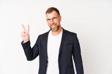 Beyaz arka planda izole edilmiş kıdemli iş adamı neşeli ve kaygısız parmakları olan bir barış sembolü gösteriyor..