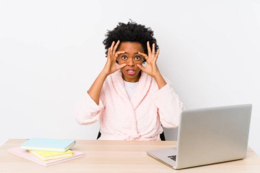 Orta yaşlı Afro-Amerikalı kadın evde tek başına çalışıyor. Gözlerini açık tutuyor ve bir başarı fırsatı arıyor..