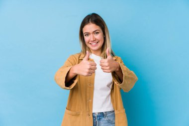 Başparmakları havada, bir konuda tezahürat yapan, destek veren ve saygı duyan beyaz bir kadın..