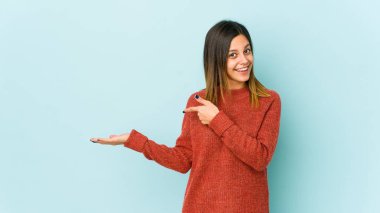 Mavi arka planda izole edilmiş genç bir kadın..