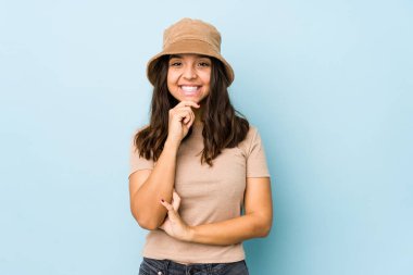 Genç, melez, yalnız, mutlu ve kendinden emin, çenesine elleriyle dokunan bir kadın..