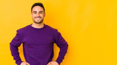 Kafkasyalı genç adam sarı fırında izole edilmiş, kendine güveni tam, elleri kalçasında..