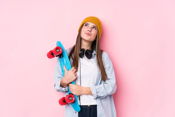 Young skater woman holding a skate dreaming of achieving goals and purposes