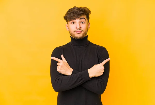 Hombre Árabe Joven Aislado Fondo Amarillo Apunta Hacia Los Lados — Foto de Stock