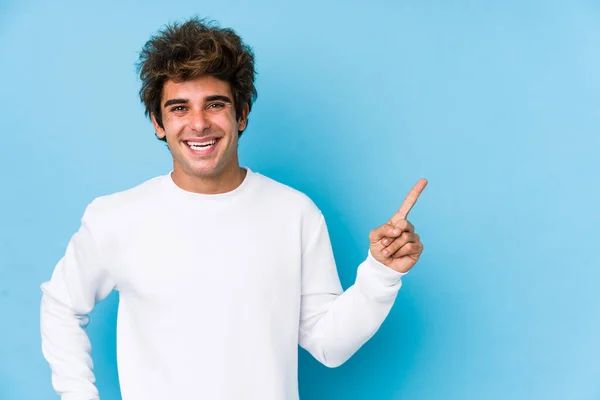 Jovem Caucasiano Contra Fundo Azul Isolado Sorrindo Alegremente Apontando Com — Fotografia de Stock