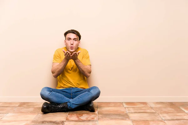 Νεαρός Καυκάσιος Κάθεται Στο Πάτωμα Απομονωμένος Πτυσσόμενα Χείλη Και Κρατώντας — Φωτογραφία Αρχείου