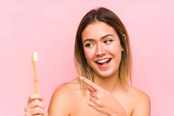 Joven Mujer Caucásica Sosteniendo Cepillo Dientes Aislado Sonriendo Alegremente Señalando — Foto de Stock