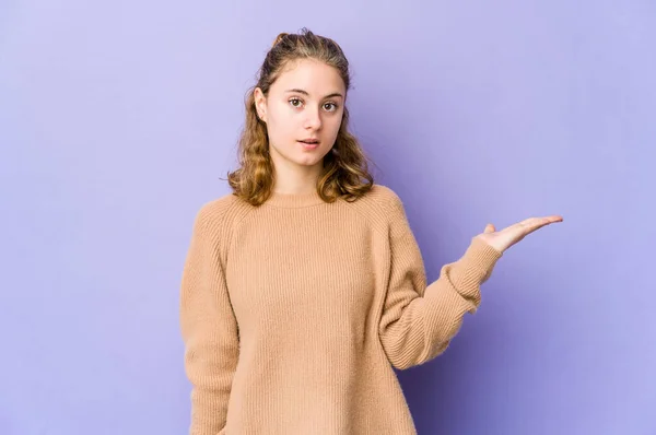 Joven Mujer Caucásica Sobre Fondo Púrpura Impresionado Sosteniendo Espacio Copia — Foto de Stock