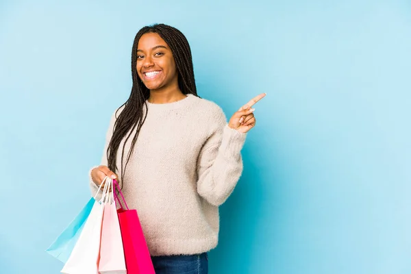 Jonge Afro Amerikaanse Vrouw Houdt Een Boodschappentas Geïsoleerd Glimlachend Wijzend — Stockfoto