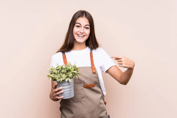 Jovem Jardineiro Mulher Caucasiana Segurando Uma Planta Isoladapessoa Apontando Mão — Fotografia de Stock