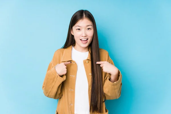 Mulher Chinesa Jovem Posando Fundo Azul Isolado Surpreso Apontando Com — Fotografia de Stock