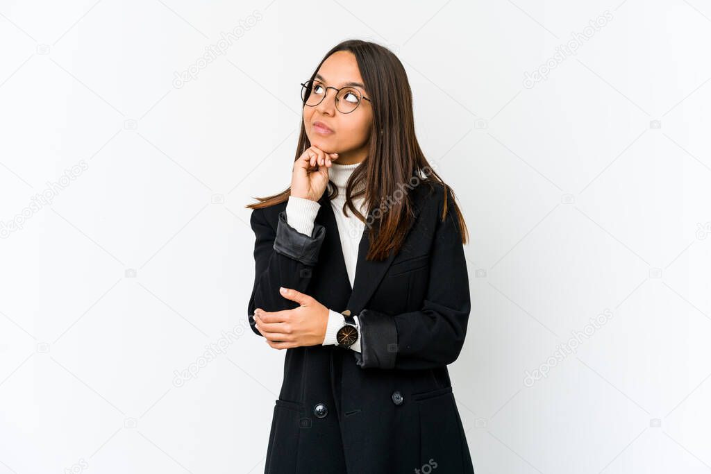 Young mixed race business woman isolated on white background relaxed thinking about something looking at a copy space.