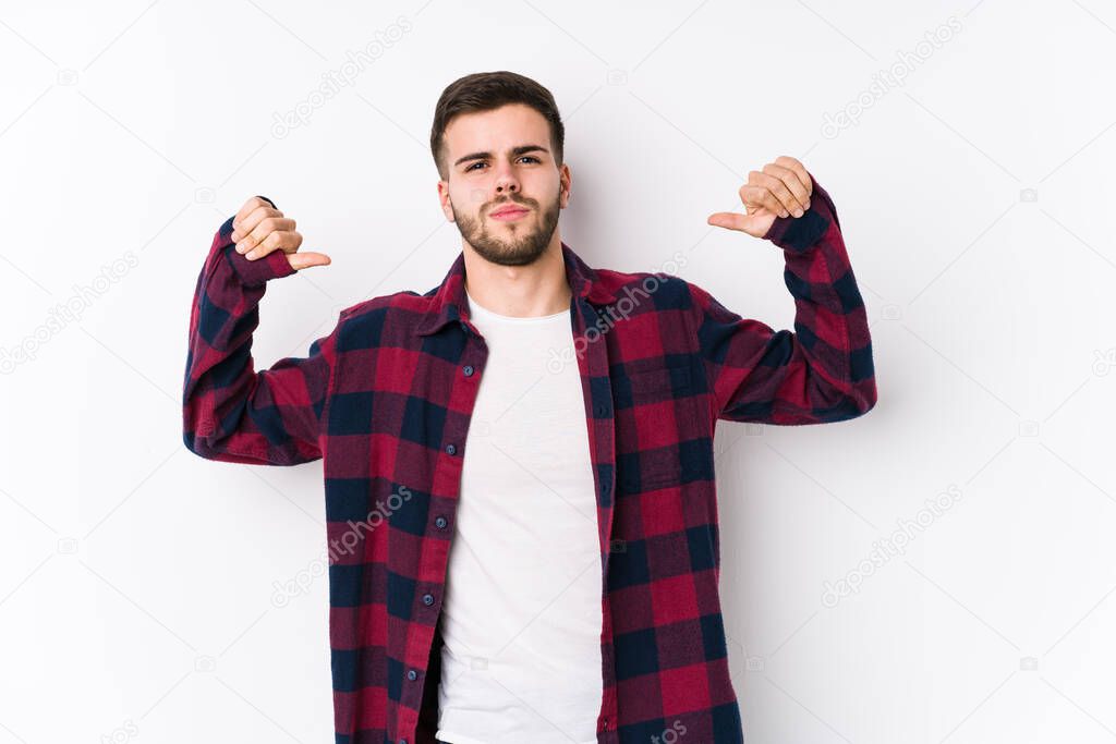 Young caucasian man posing in a white background isolated feels proud and self confident, example to follow.