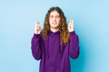 Uzun saçlı adam şans dilemek için izole edilmiş parmaklar kullanıyor.