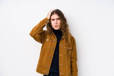 Uzun saçlı adam yalnız poz veriyor. Çok yorgun ve uykulu. Elini başının üstünde tutuyor..