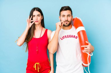 Genç cankurtaran çifti dudaklarında parmaklarıyla bir sır saklıyorlar..