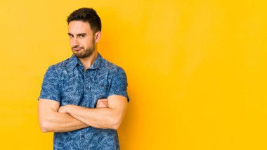 Kafkasyalı genç adam sarı fırında izole edilmiş hoşnutsuzca kaşlarını çatmış, kollarını kavuşturmuş..