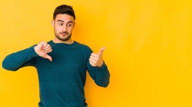 Kafkasyalı genç adam sarı fırında izole edilmiş, baş parmağını kaldırmıyor, zor seçim konsepti.