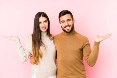 Kafkasyalı genç çift kollarıyla ölçek yapar, mutlu ve kendinden emin hissederler..