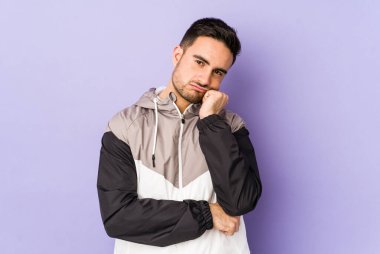 Mor arka planda izole edilmiş genç beyaz adam tekrarlanan bir görevden bıktı..