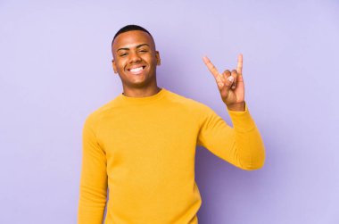 Mor arka planda izole edilmiş genç Latin bir adam boynuzları devrim konsepti olarak gösteriyor..