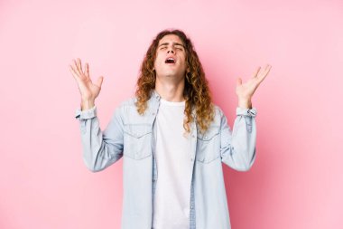 Uzun saçlı adam yalnız poz veriyor gökyüzüne haykırıyor, yukarı bakıyor, hayal kırıklığına uğramış.