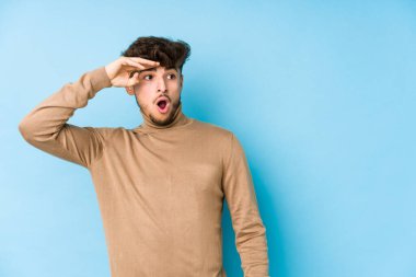 Genç Arap adam izole edilmiş, uzaklara bakıyor ve elini alnına koyuyor..