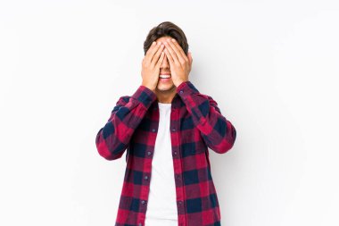 Pembe arka planda poz veren beyaz bir genç yalnız gözlerini elleriyle kapatıyor, gülümseyerek bir sürpriz bekliyor..