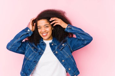 Genç Afrikalı Amerikalı kadın ellerini başının üstünde tutarak neşeyle gülüyor. Mutluluk kavramı.