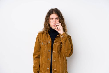 Uzun saçlı adam tırnak yiyor, gergin ve endişeli..