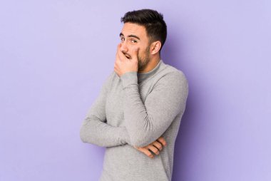 Mor arka planda izole edilmiş genç beyaz adam korkmuş ve korkmuş..