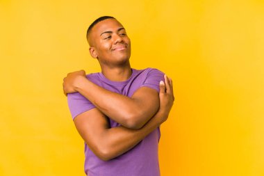 Genç latin adam sarı arka planda yalnızdı. Sarılmalar, kaygısız gülümsemeler ve mutluluklar..