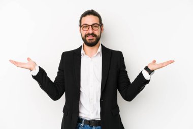 Beyaz bir arka planda izole genç beyaz iş adamı kollarıyla ölçek yapar, mutlu ve kendinden emin hisseder..