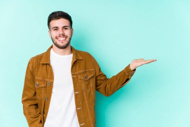 Genç yakışıklı bir adam avucunun içinde fotokopi odası gösteriyor ve başka bir eli belinde tutuyor..