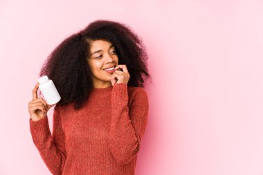 Vitaminlerini tutan genç afro bir kadın vitaminli genç bir afro kadını izole etti. Bir şeyin fotokopi odasına baktığını düşünüyordu..
