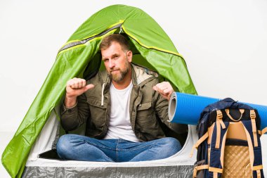 Beyaz arka planda izole edilmiş bir çadırın içindeki son sınıf öğrencisi gururlu ve kendinden emin hissediyor..