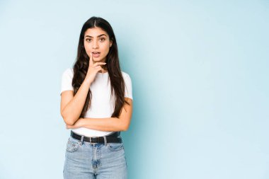 Mavi arka planda yaşayan genç Hintli kadının harika bir fikri var, yaratıcılık kavramı..