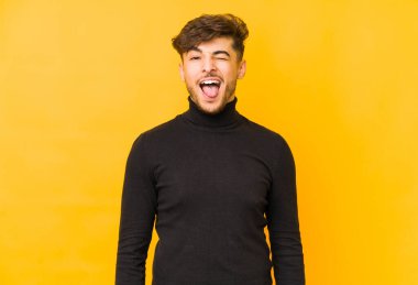 Sarı arka planda izole edilmiş genç bir Arap. Komik ve dost canlısı bir dil..