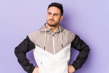 Mor arka planda izole edilmiş genç beyaz adam hedeflere ve amaçlara ulaşmayı hayal ediyor.