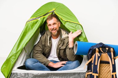 Beyaz arka planda izole edilmiş bir çadırın içinde bir avuç içinin fotokopi çekilen ve belinde bir el daha tutulan bir yer var..